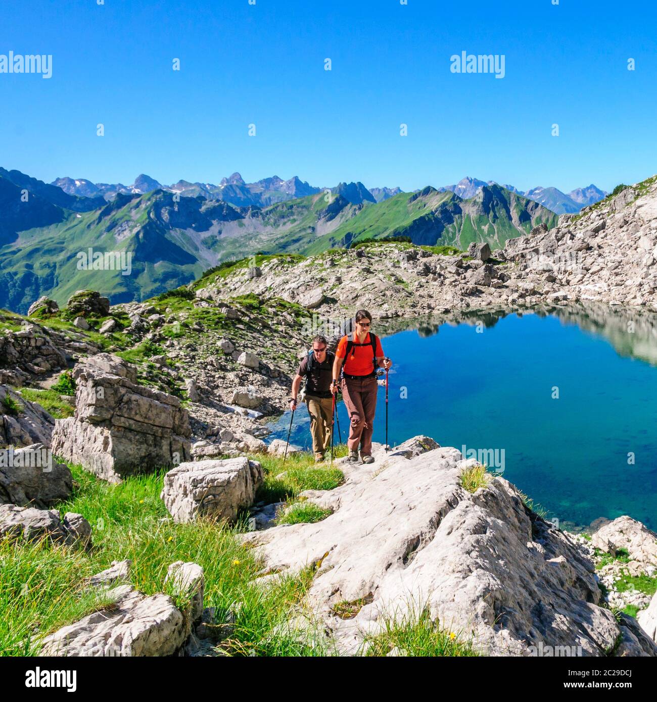 Pärchen wandern in der Morgensonne am Nebelhorn in den Allgäuer Alpen Stockfoto