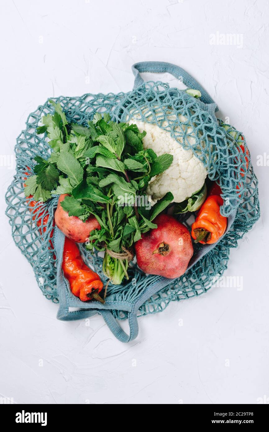 Flatlay von Null Abfall nachhaltige Lebensmittel einkaufen, verschiedene Früchte, Gemüse und Gemüse in einem blauen Netzbeutel Stockfoto