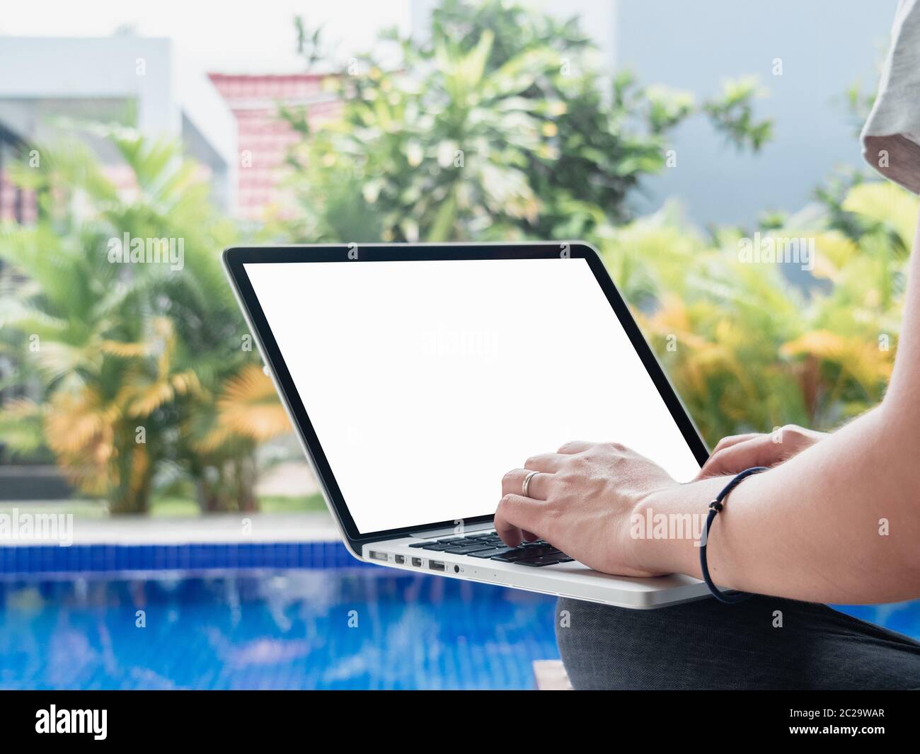 Junge Frauen arbeiten am Pool. Weibliche Telearbeiter schreiben Code, Studie, Surfen im Internet im Sommer. Nahaufnahme der manuellen Eingabe auf Compute Stockfoto