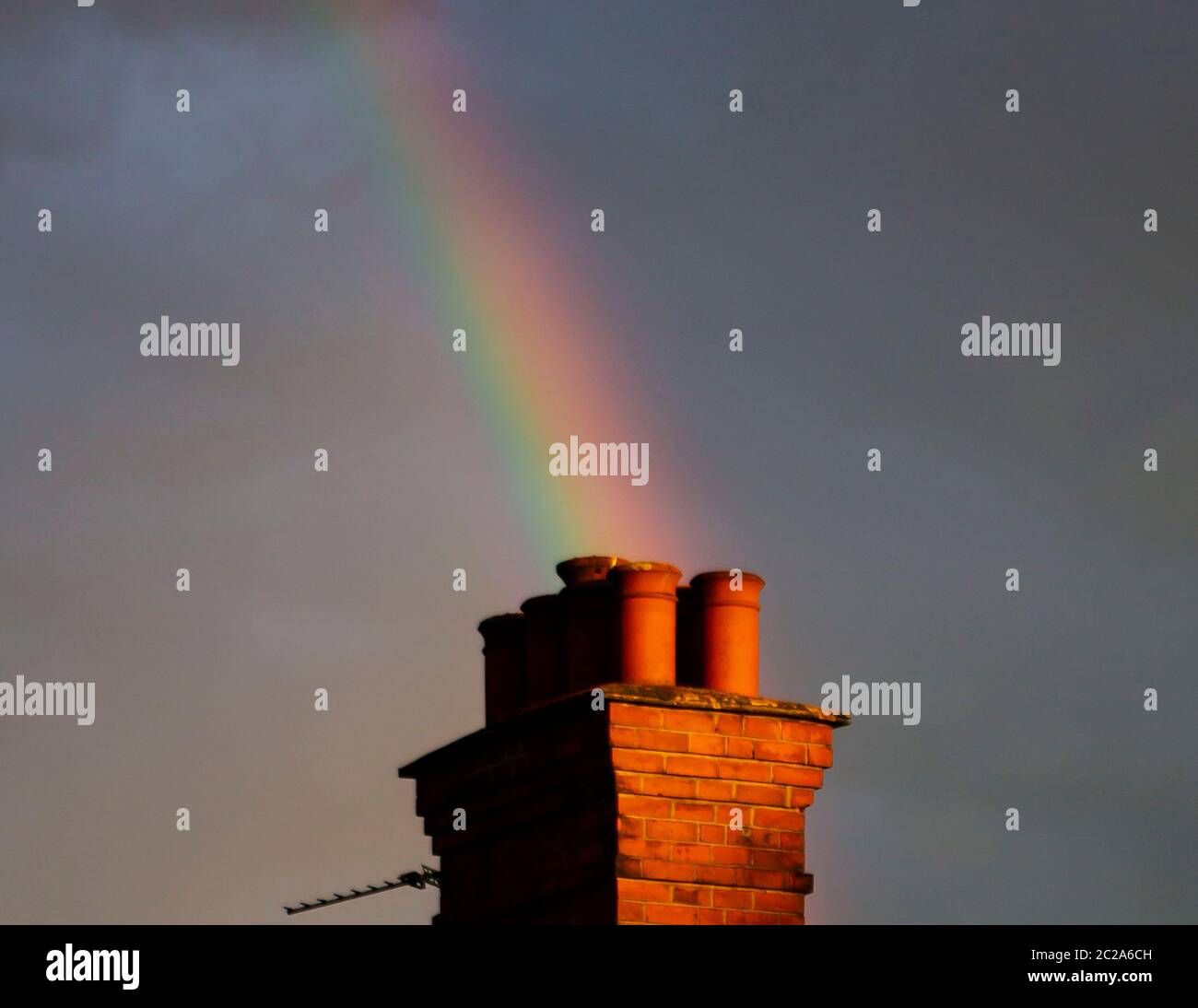 Regenbogen erscheint hinter einem Kamin Stockfoto