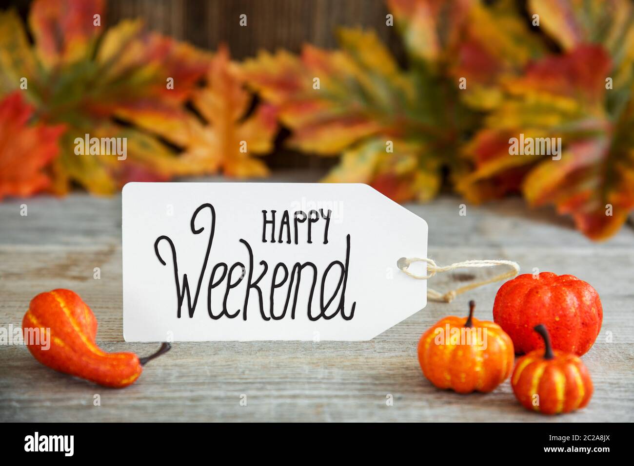 White Label mit englischem Text Happy Weekend. Hintergrund mit Holz Herbst Dekoration wie Kürbis und Blätter Stockfoto
