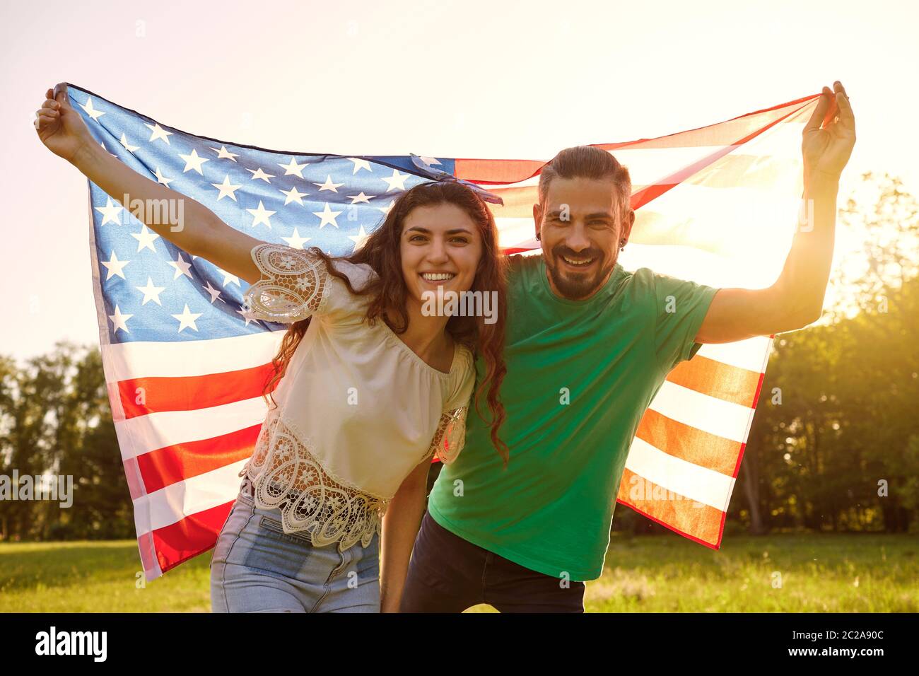 Paar mit amerikanischer Flagge feiert amerika Unabhängigkeitstag im Park stehen. Stockfoto