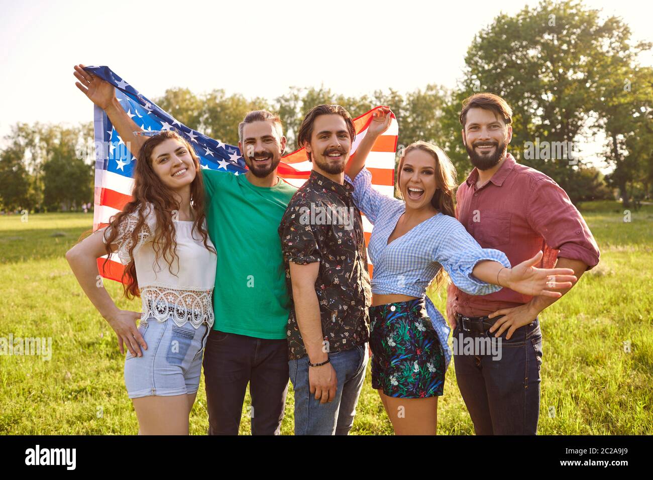 Gruppe von jungen Menschen mit amerikanischer Flagge feiern amerika Unabhängigkeitstag im Park stehen. Stockfoto