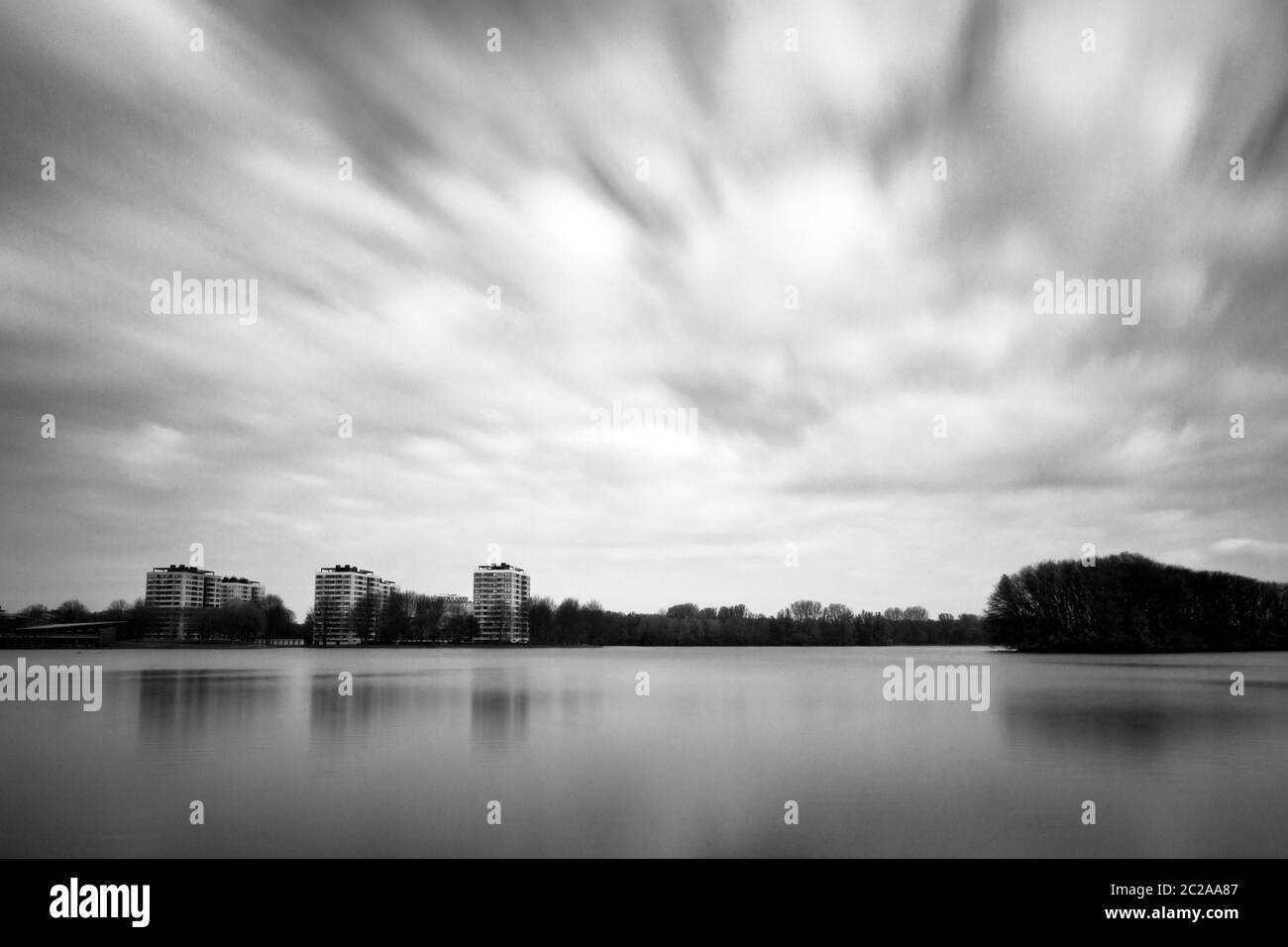 Langzeitbelichtung schwarz-weiße Landschaft an der Sloterplas in Amsterdam, Niederlande, mit Wolken vorbei Stockfoto