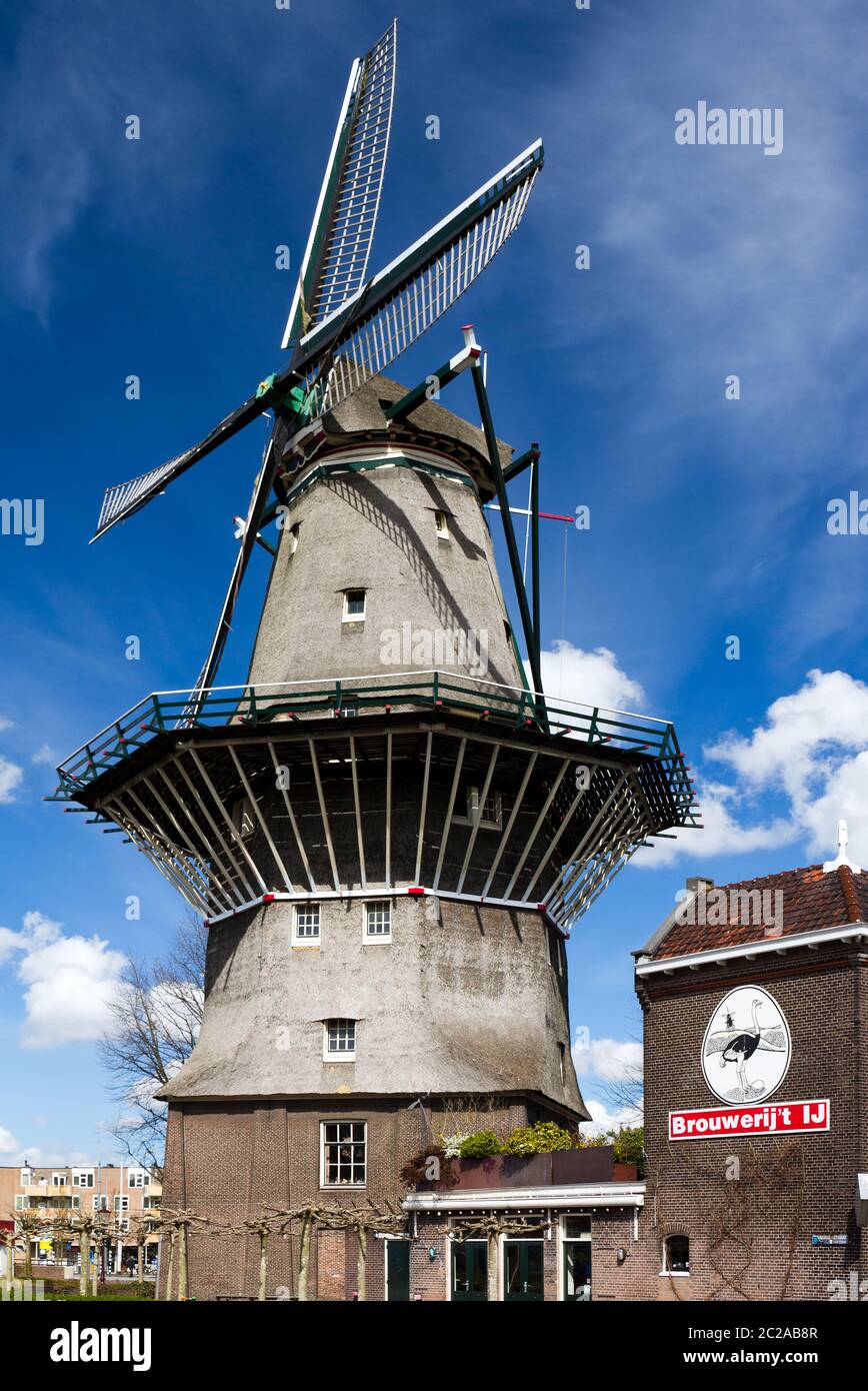 Niederländische Windmühle gegen einen schönen blauen Himmel mit Wolken in Amsterdam, Niederlande Stockfoto