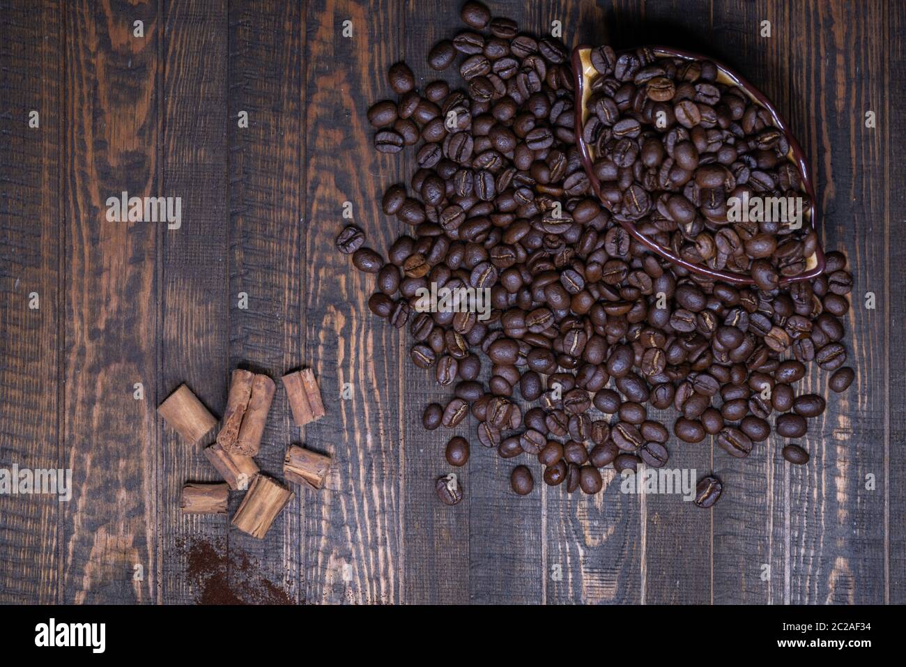 Kaffeebohnen in eine Tasse und Zimt auf einem Holztisch Stockfoto