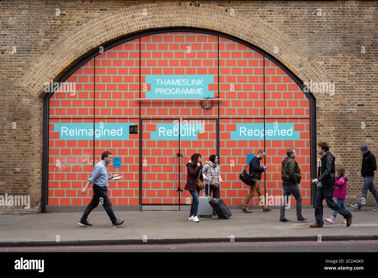 Menschen, die an Wandgemälden vorbeilaufen, die das Thameslink-Programm an der London Bridge Station in Duke St Hill London wie im Januar 2020 anwerben Stockfoto