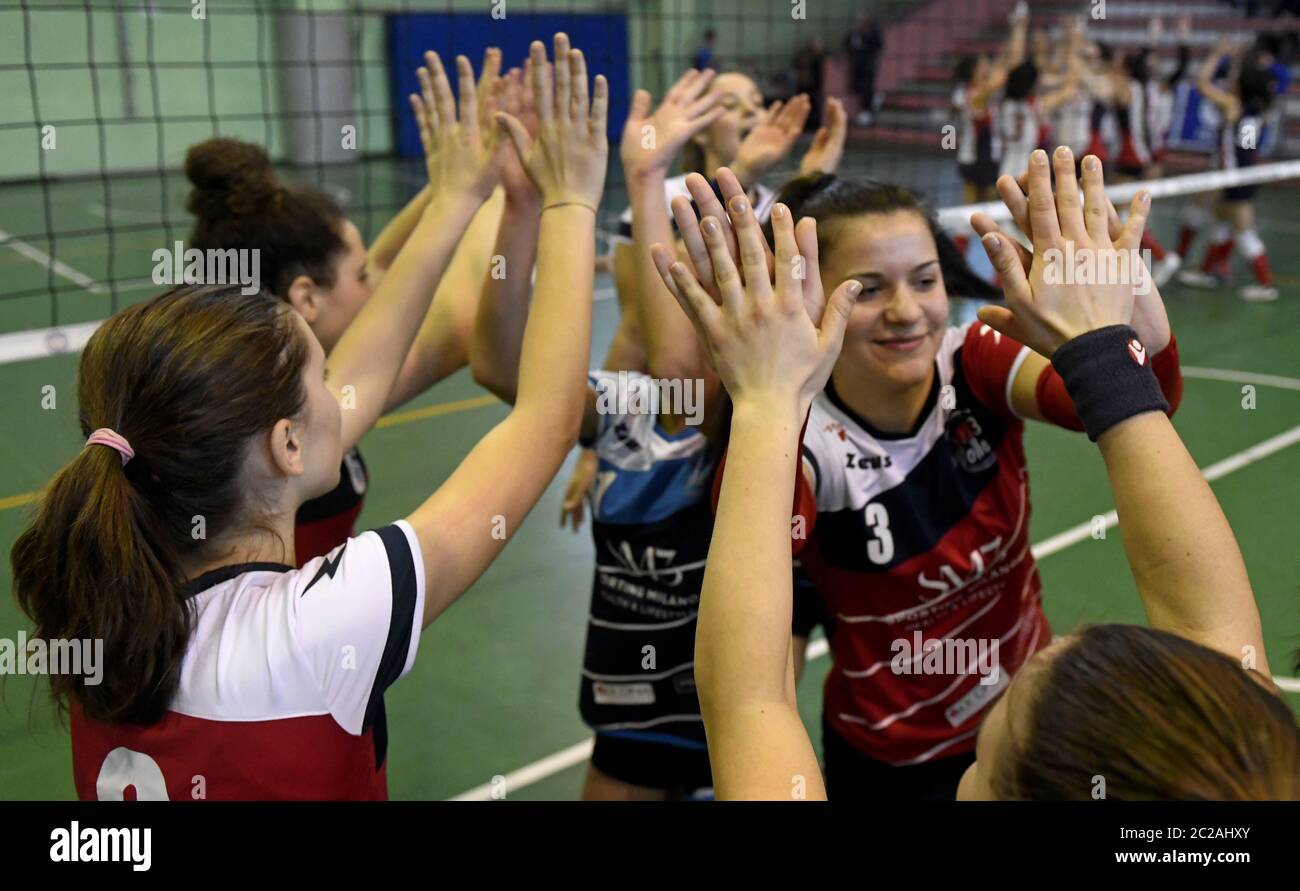 Junge weibliche Volleyball-Teamkollegen unterstützen sich gegenseitig, während eines Jugend-Volleyball-Finale, in Mailand. Stockfoto