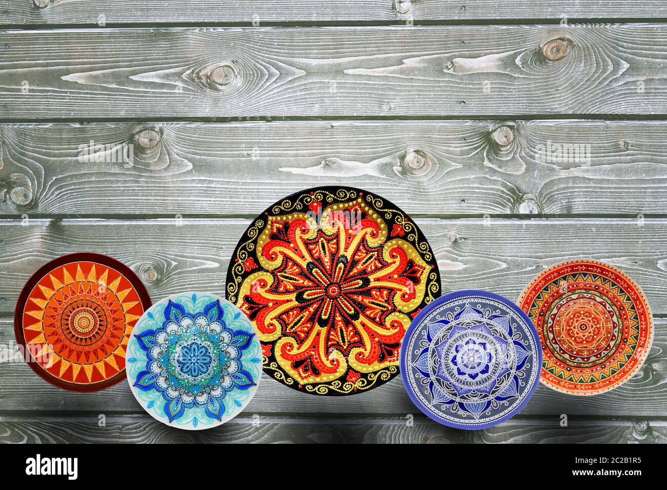 Der dekorative Keramik Teller handbemalt Dot Pattern mit Acrylfarben auf grauem Hintergrund aus Holz. Kopieren Sie Platz. Stockfoto