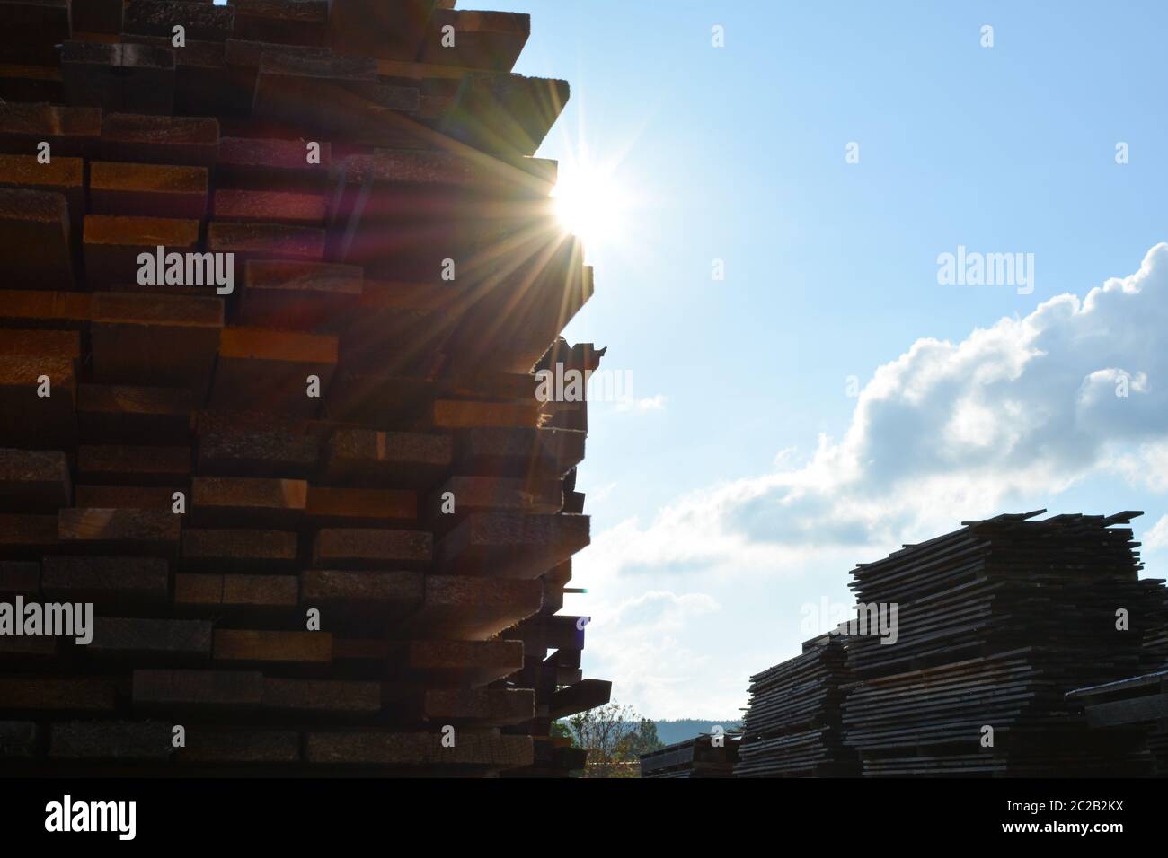 Gestapelte Holzbretter in einem Sägewerk Lager mit heller Sonne und blauem Himmel Stockfoto