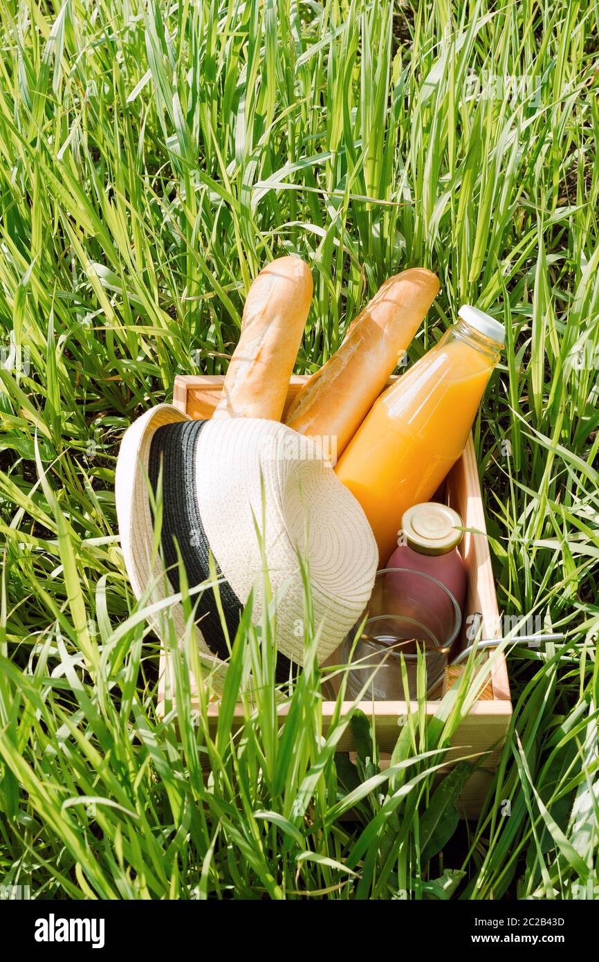 Hüte und kalte Getränke in einer Holzkiste auf einem Rasen, Sommer Picknick-Konzept Stockfoto
