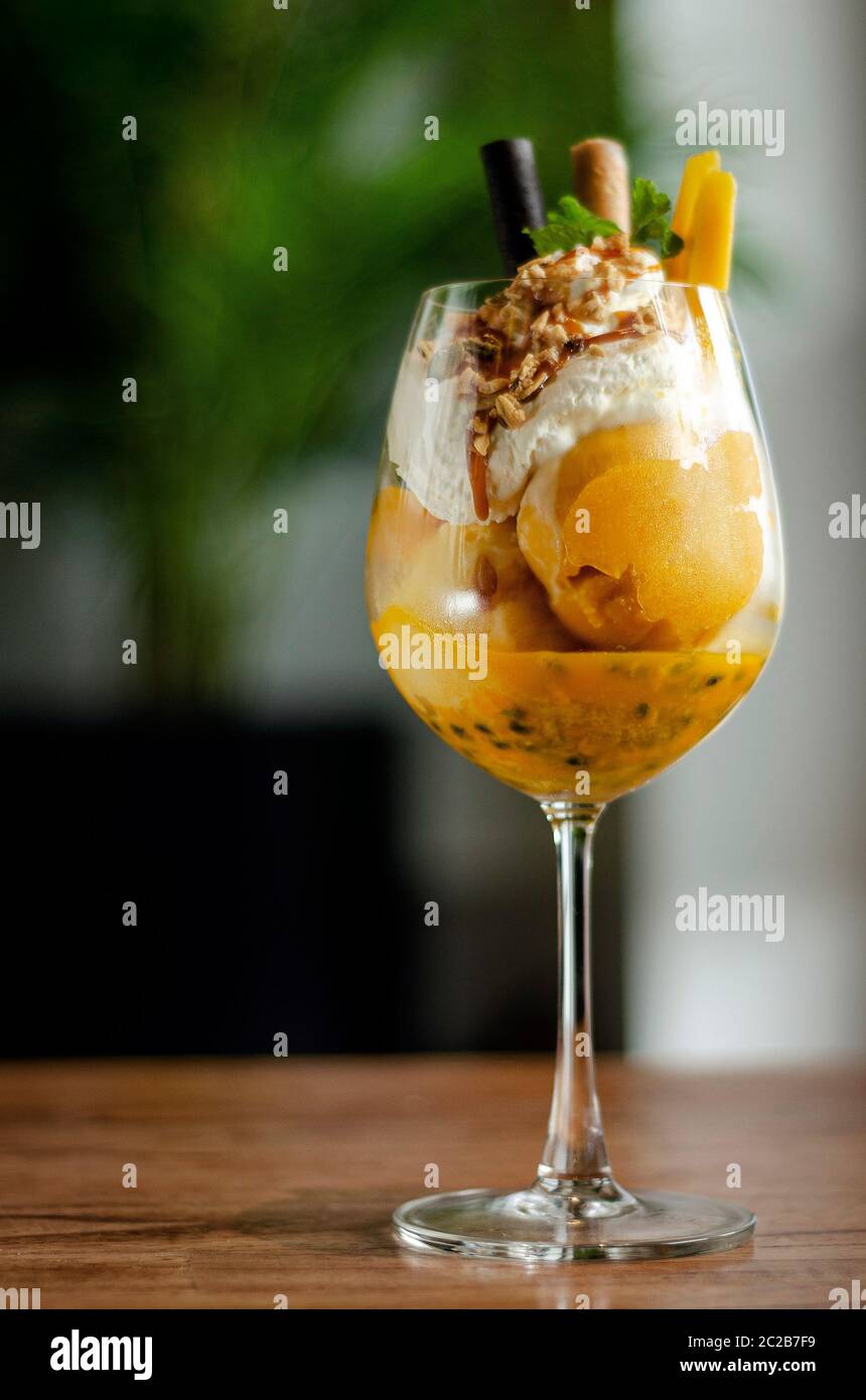 Bio Mango und Passionsfrucht tropische Eisbecher in Wein Glas Stockfoto