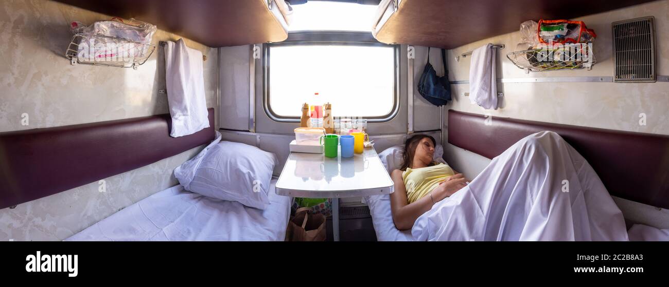 Panorama der Innenraum eines reservierten Sitz Zug Auto, einem Mädchen schlafen in einem der unteren Regale Stockfoto