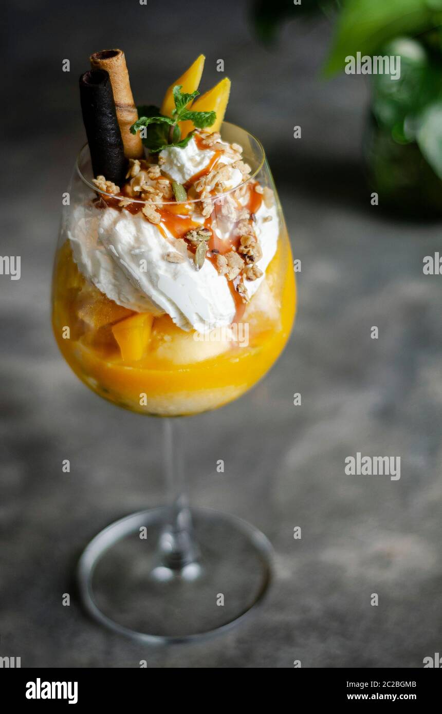 Bio Mango und Passionsfrucht tropische Eisbecher in Wein Glas Stockfoto