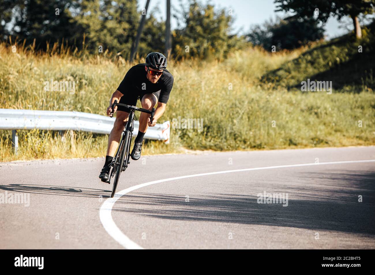 Reifer bärtiger Radfahrer im Sport-Outfit und Schutzhelm Fahrrad fahren an der frischen Luft. Sportler, der aktiven Lebensstil mit grüner Natur führt. Stockfoto