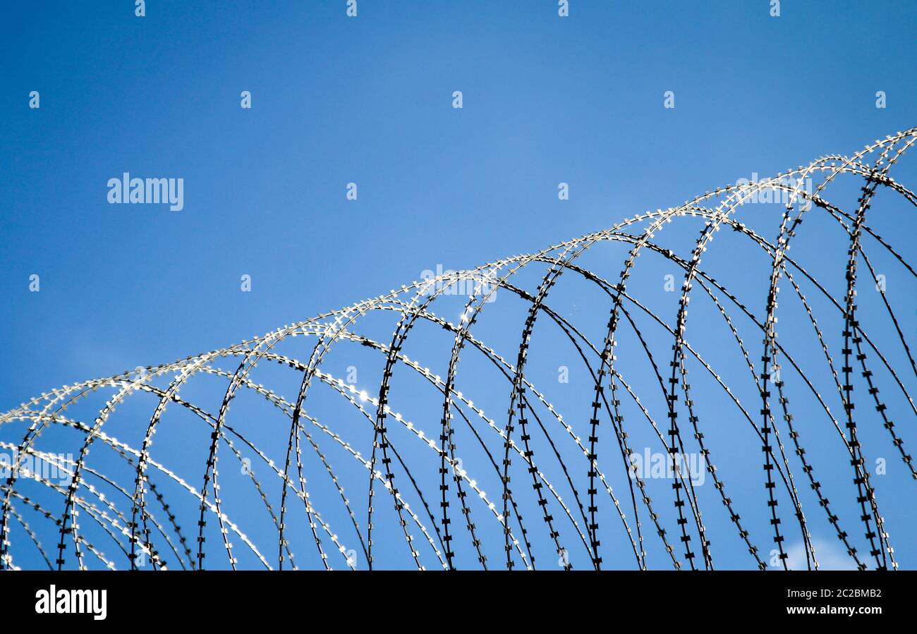 Stacheldraht an einem Zaun eines Gefängnisses, um unbefugten Zutritt zu verhindern Stockfoto