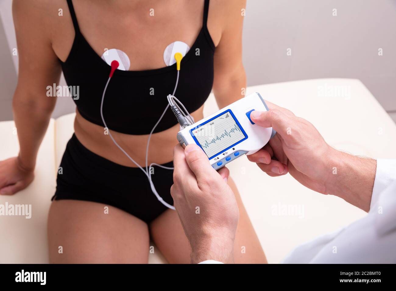 Arzt anwenden Holter-monitor Gerät am Körper der Frau für die tägliche Überwachung der Ein Elektrokardiogramm Stockfoto