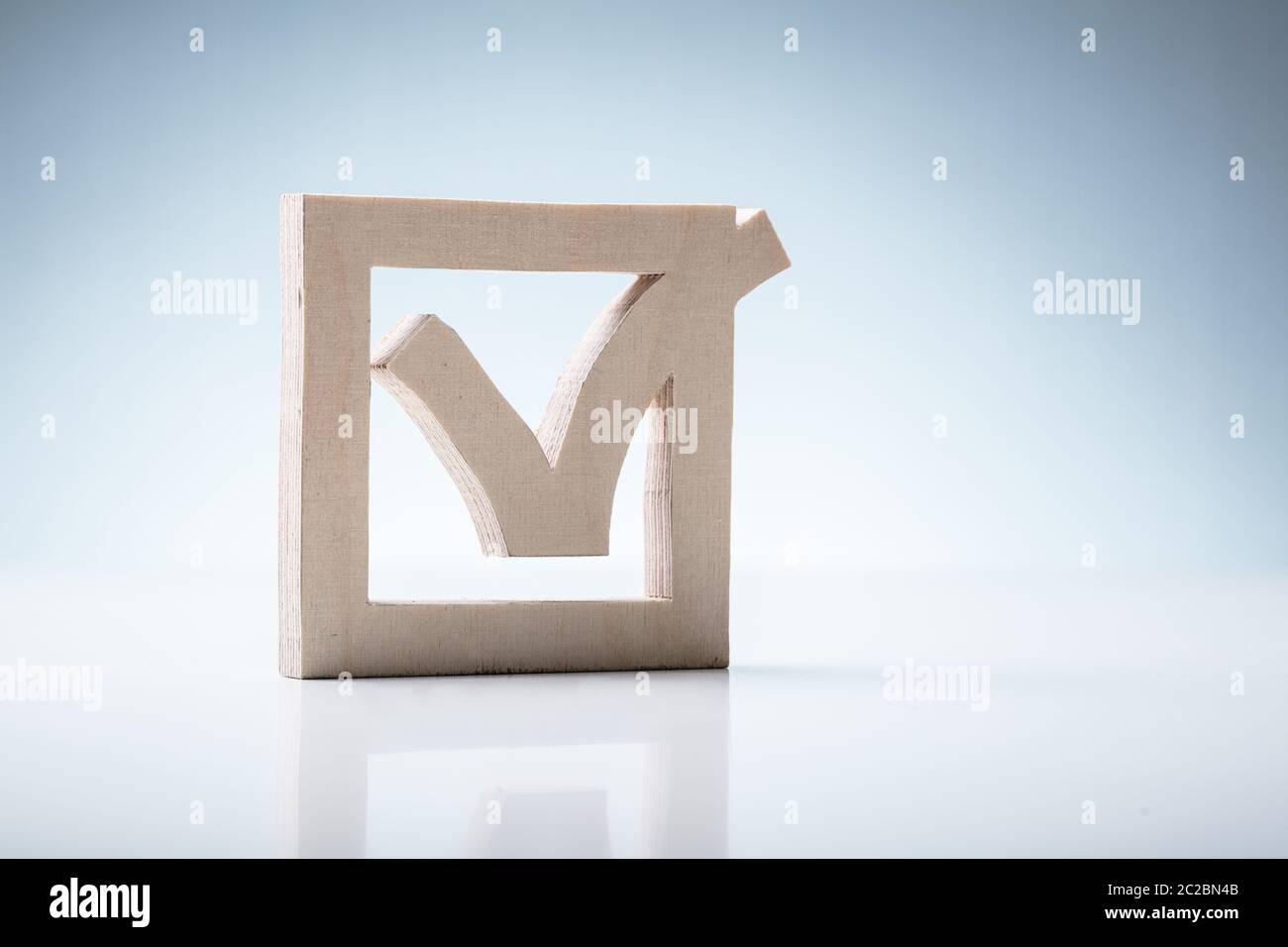 Holz- Kontrollkästchen isoliert auf weißem Hintergrund über Schreibtisch Stockfoto