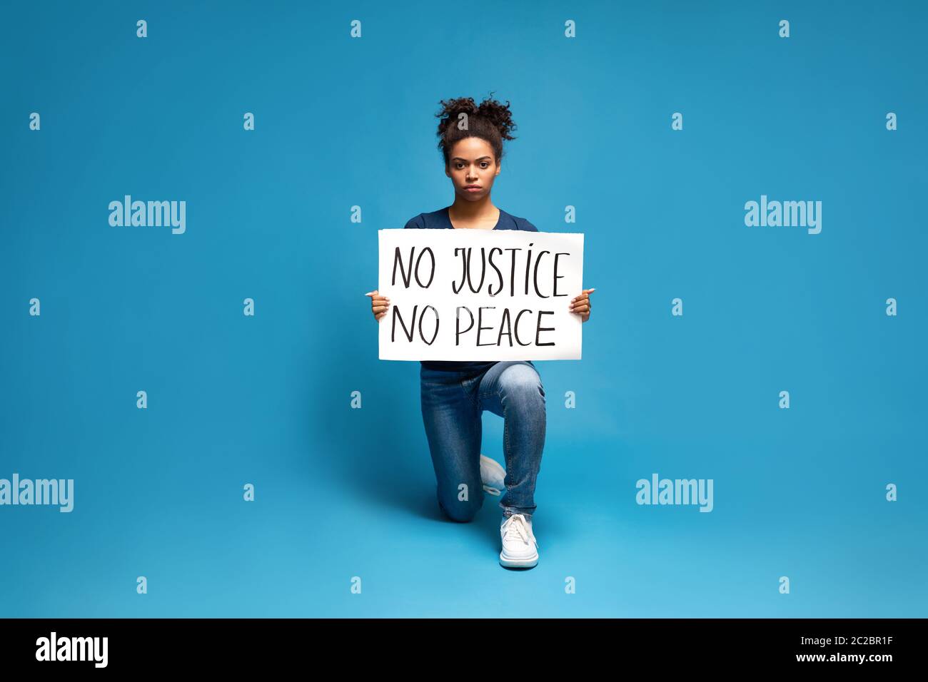 Schwarze Frau protestiert mit Plakat No Justice No Peace Stockfoto