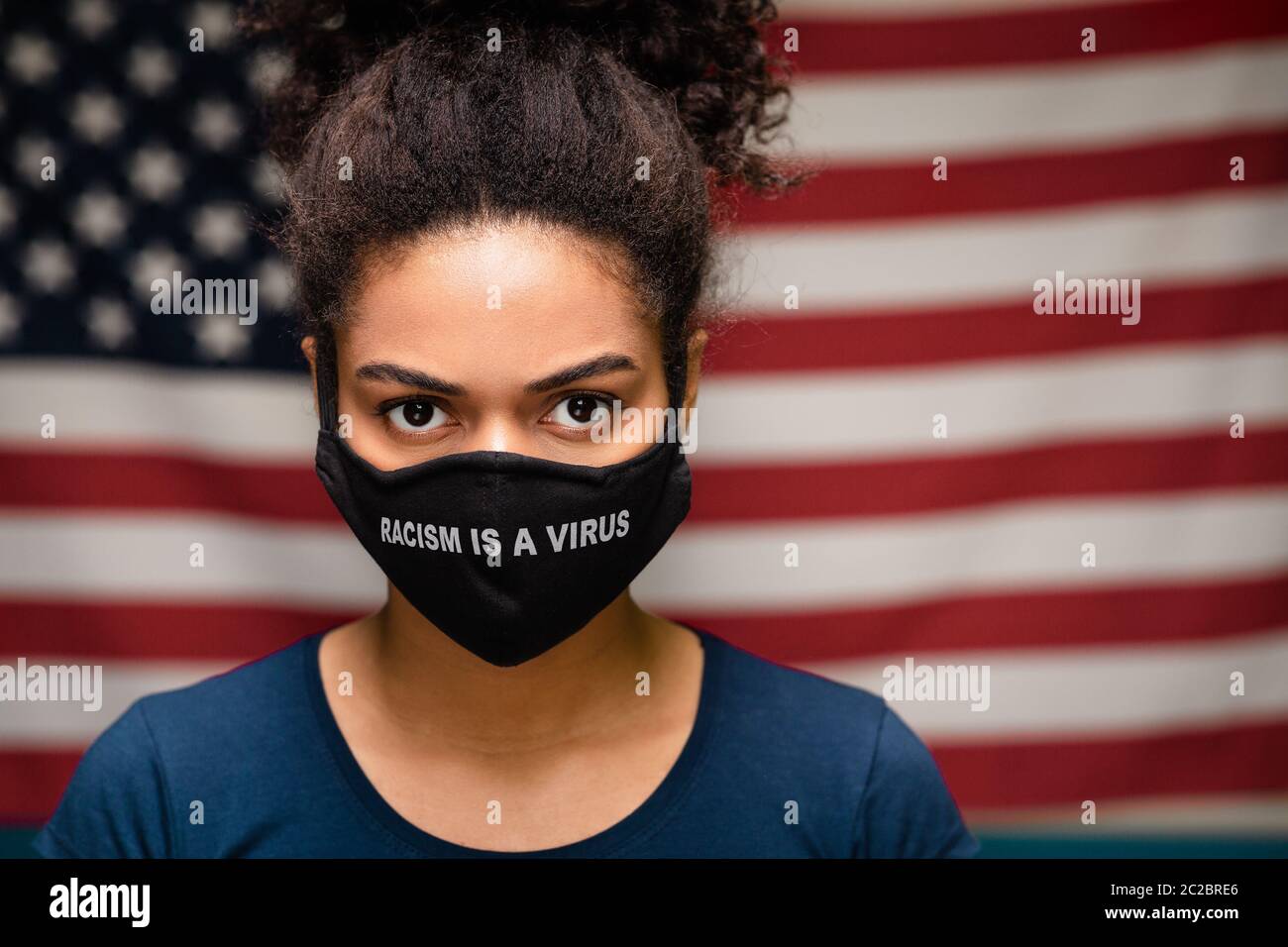 Schwarze Frau trägt Schutzmaske Text Rassismus ist ein Virus Stockfoto