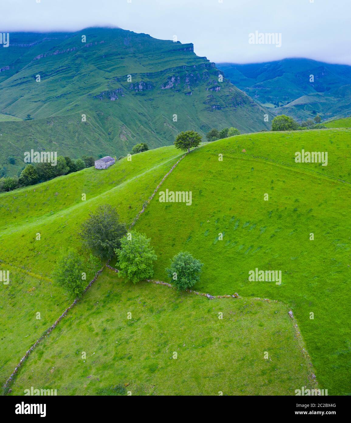 Luftaufnahme mit einer Drohne von der Frühlingslandschaft von paliegas Hütten und Wiesen im Miera Tal in der Autonomen Gemeinschaft Kantabrien. Spanien, Europa Stockfoto