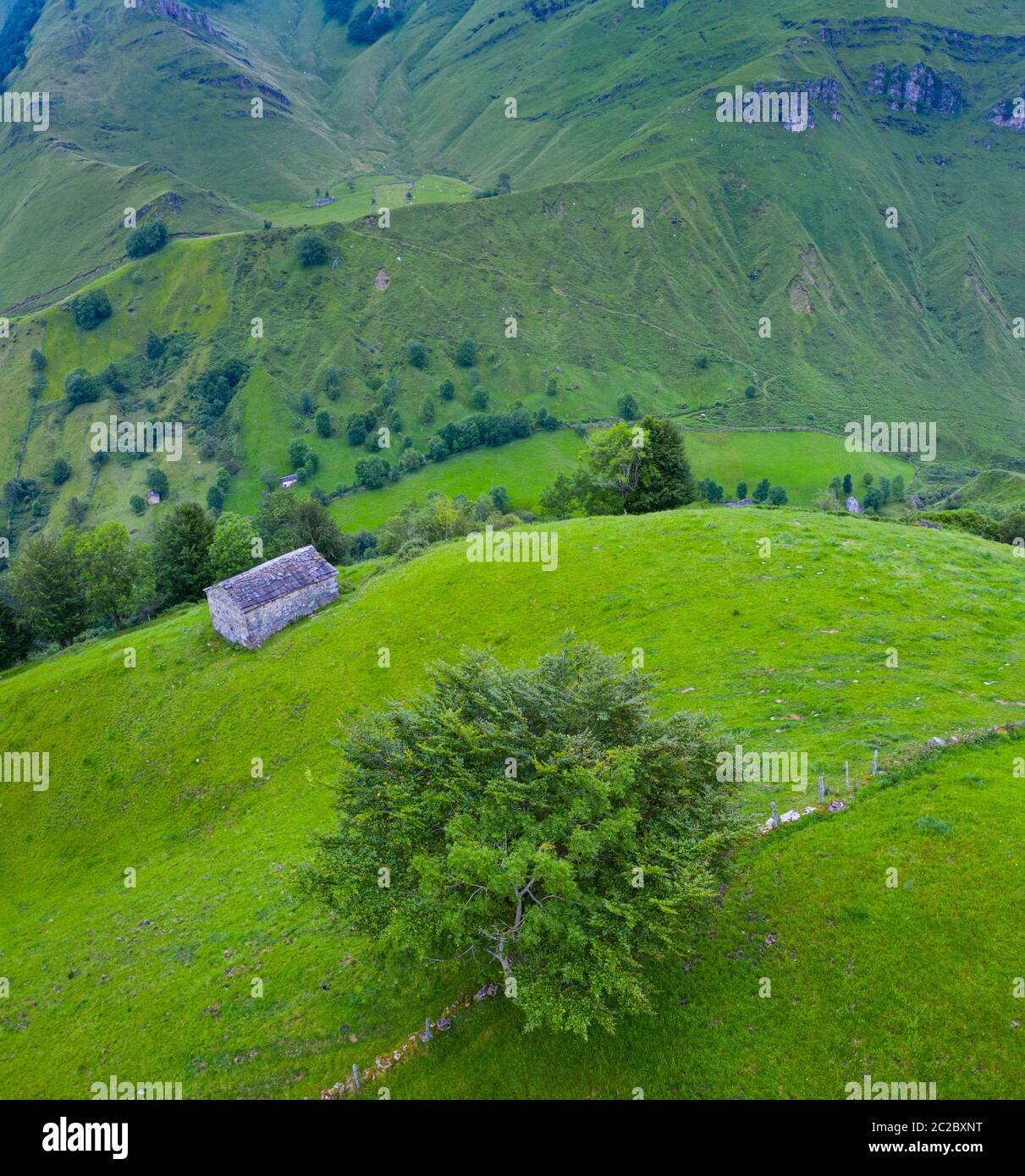 Luftaufnahme mit einer Drohne von der Frühlingslandschaft von paliegas Hütten und Wiesen im Miera Tal in der Autonomen Gemeinschaft Kantabrien. Spanien, Europa Stockfoto