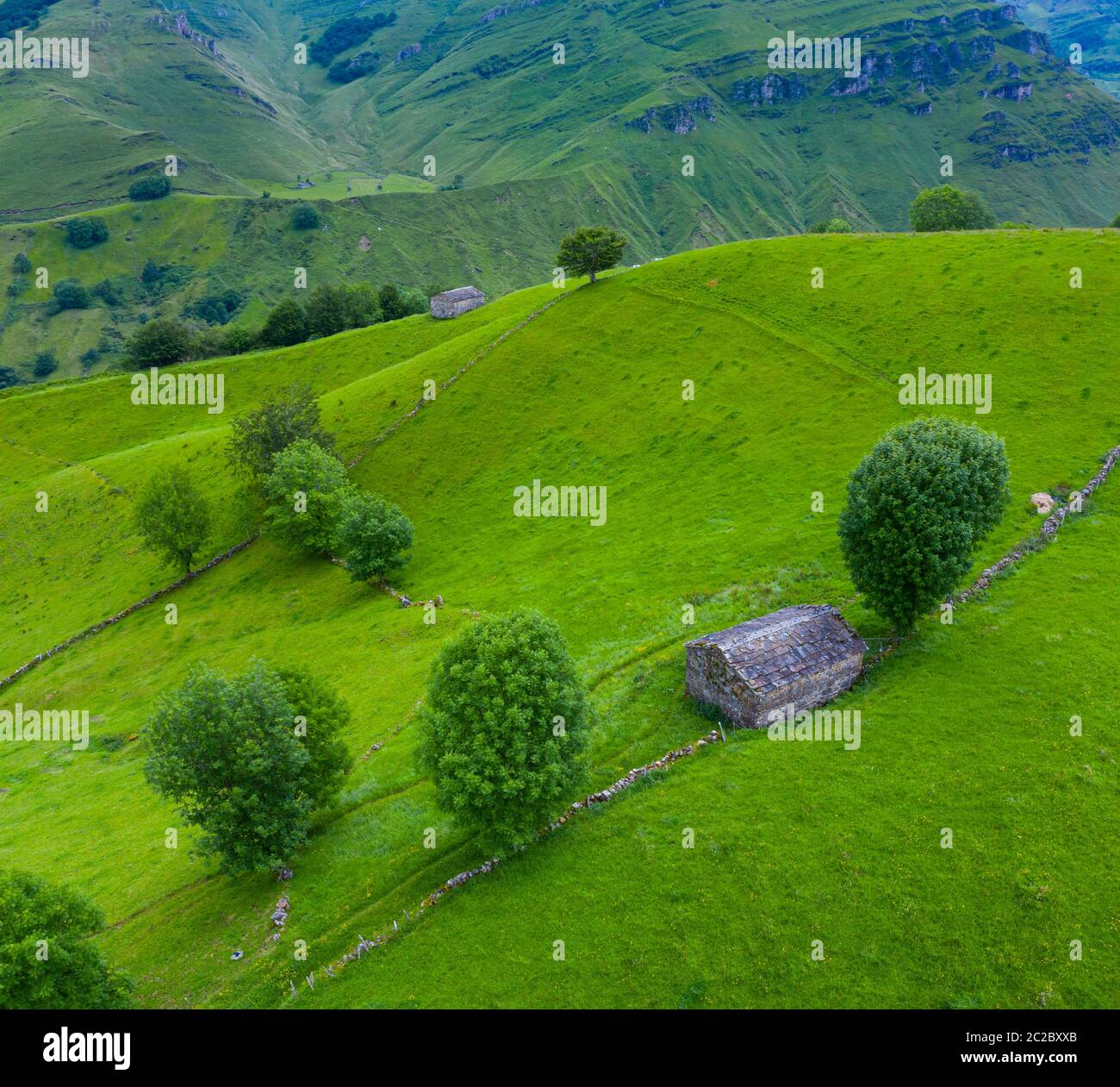 Luftaufnahme mit einer Drohne von der Frühlingslandschaft von paliegas Hütten und Wiesen im Miera Tal in der Autonomen Gemeinschaft Kantabrien. Spanien, Europa Stockfoto