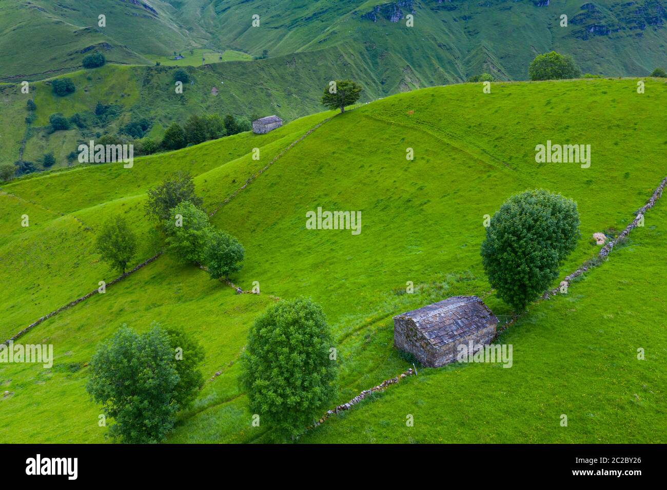 Luftaufnahme mit einer Drohne von der Frühlingslandschaft von paliegas Hütten und Wiesen im Miera Tal in der Autonomen Gemeinschaft Kantabrien. Spanien, Europa Stockfoto