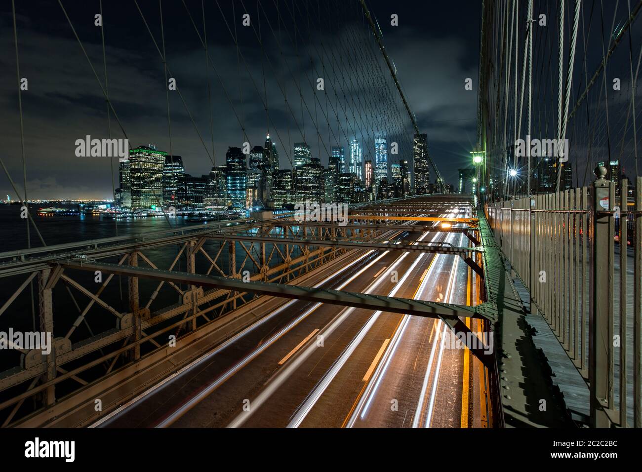 Dämmerung viel Verkehr über die Brooklyn Bridge und Lower Manhattan Skyline, New York, United States Stockfoto