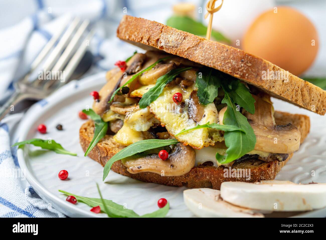 Scheiben geröstetes Brot mit Ei und Pilzen. Stockfoto