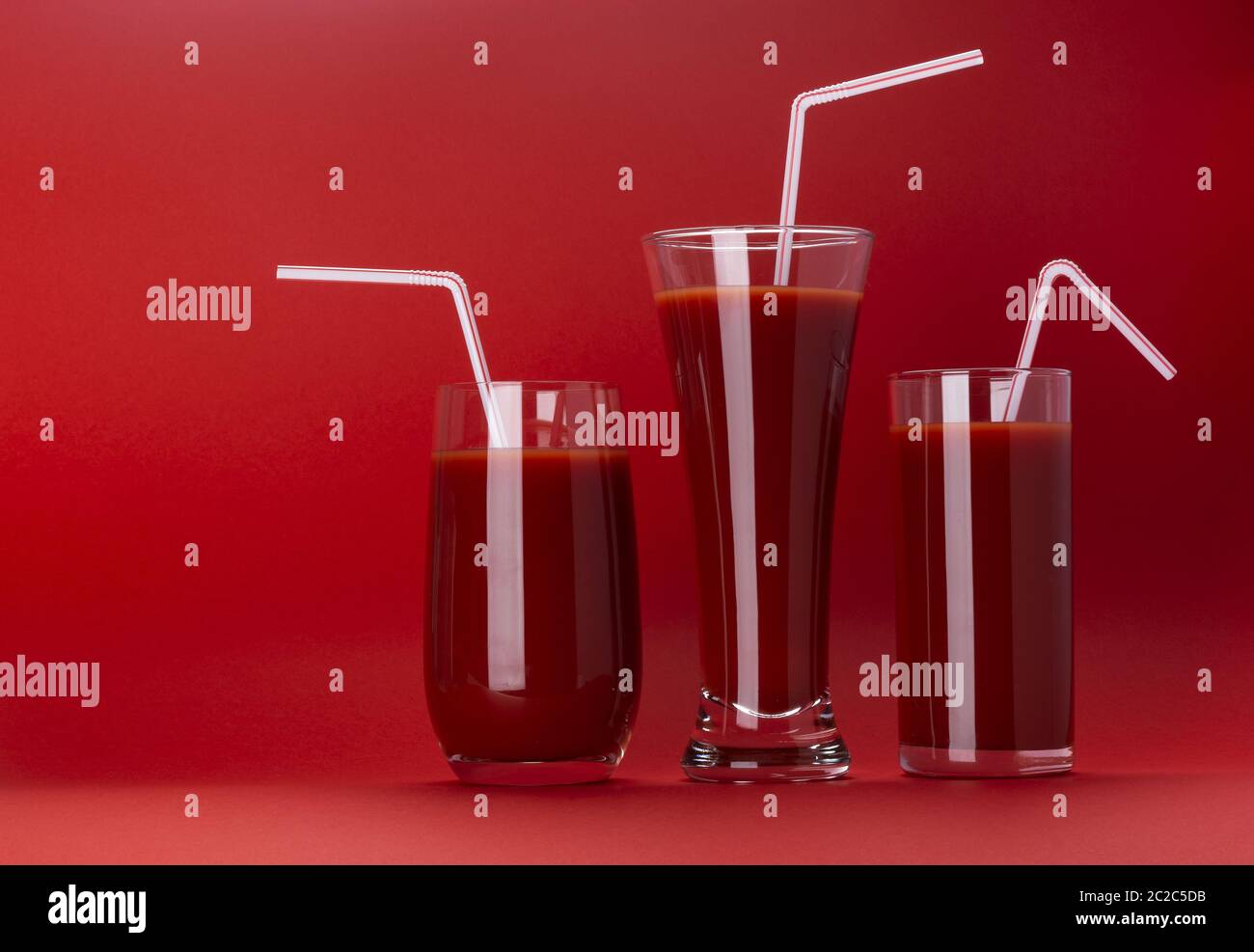 Glas Tomatensaft auf rotem Hintergrund mit Kopie Raum Stockfoto