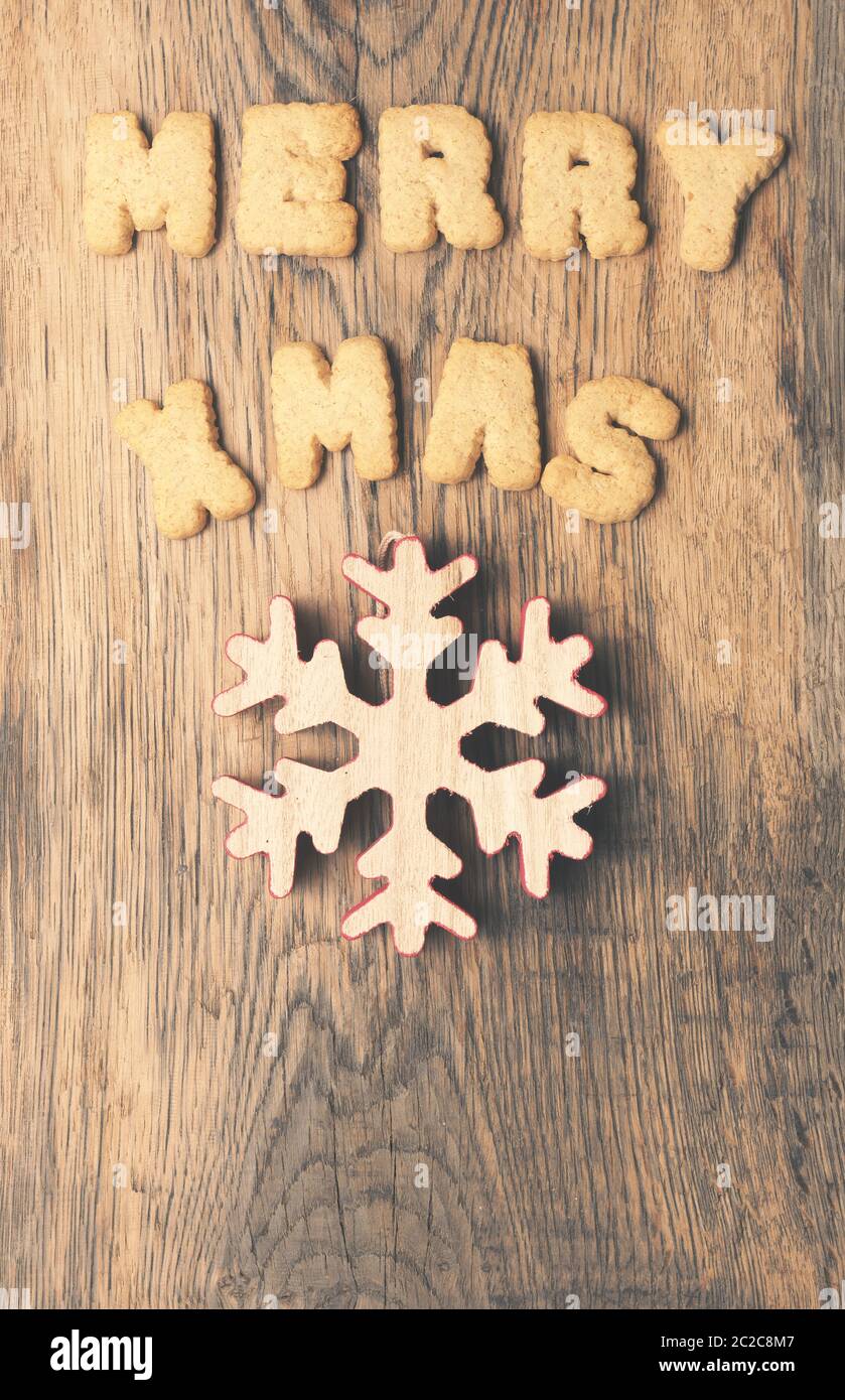 Weihnachtsbaum Form der Tannenzapfen mit den Worten Merry X-Mas auf einem rustikalen Holzbrett Stockfoto
