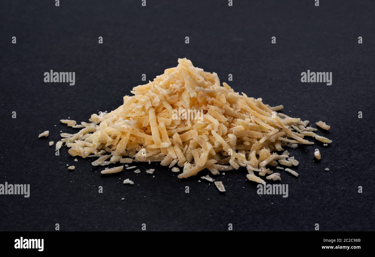 Geriebenen Parmesan auf schwarzem Hintergrund Stockfoto