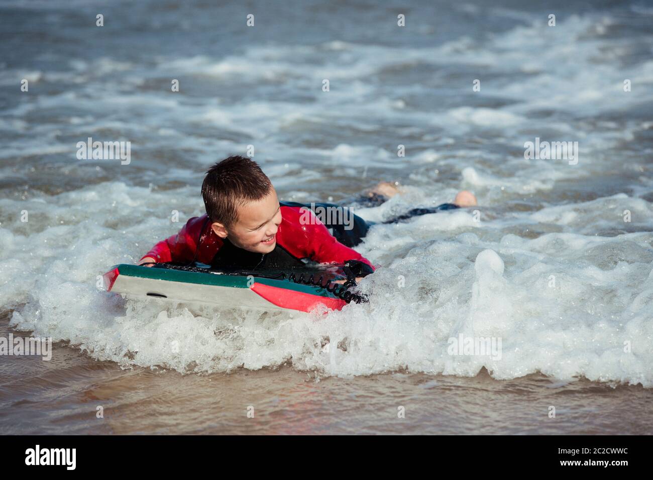Little Boy Bodyboarding im Meer Stockfoto