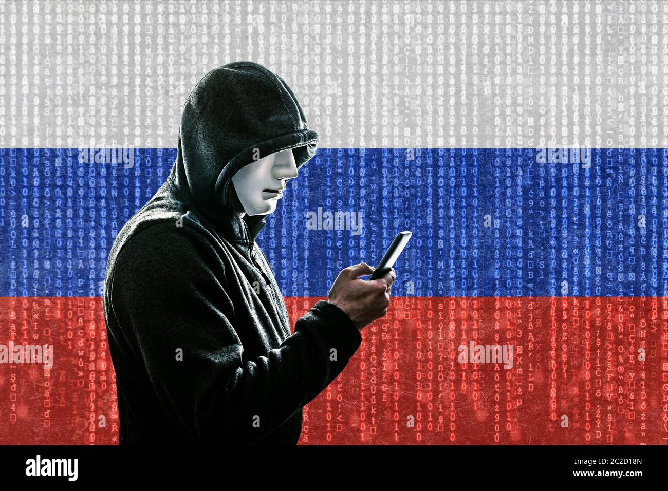 Russische Hacker mit Maske mit Kapuze holding Smartphone Stockfoto