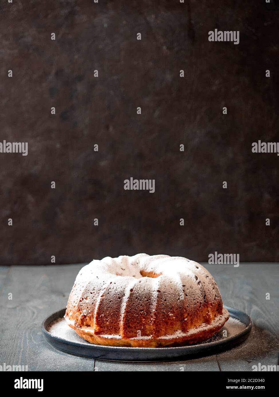Weibliche Hand bestreuen Puderzucker auf Muffin Kuchen Stockfoto
