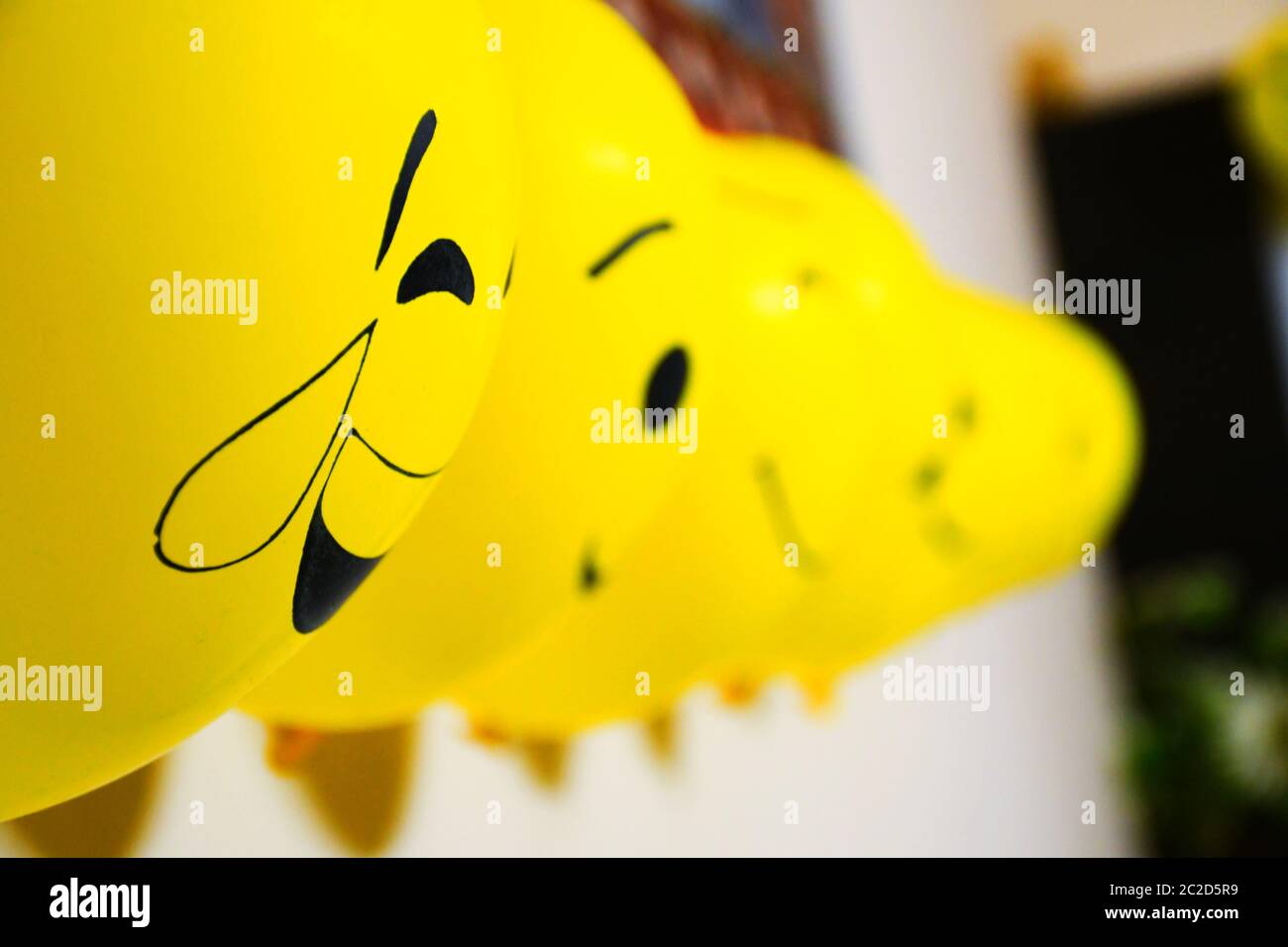 Luftballons Dekoration an der Wand, Emoji Gesichter auf Luftballons Stockfoto