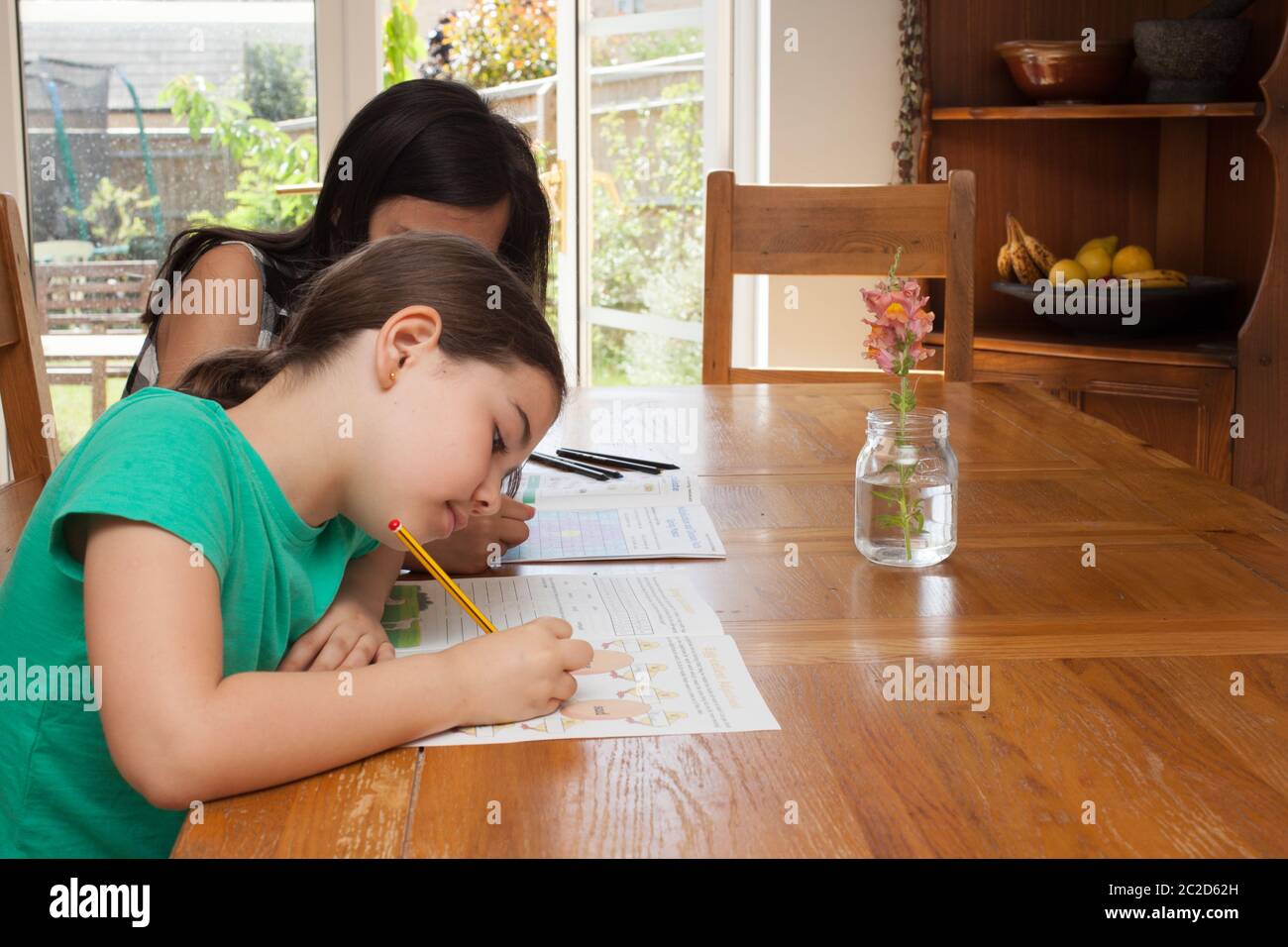 Zwei Mädchen zu Hause Schulbildung aus der Küche Tisch Stockfoto