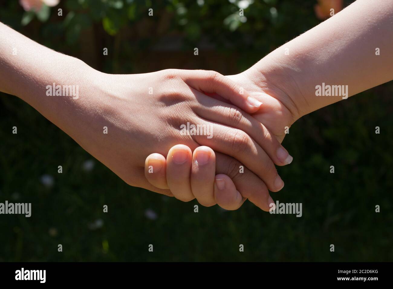 Zwei Mädchen Hände zusammen gehalten bieten Nähe und Freundschaft Stockfoto