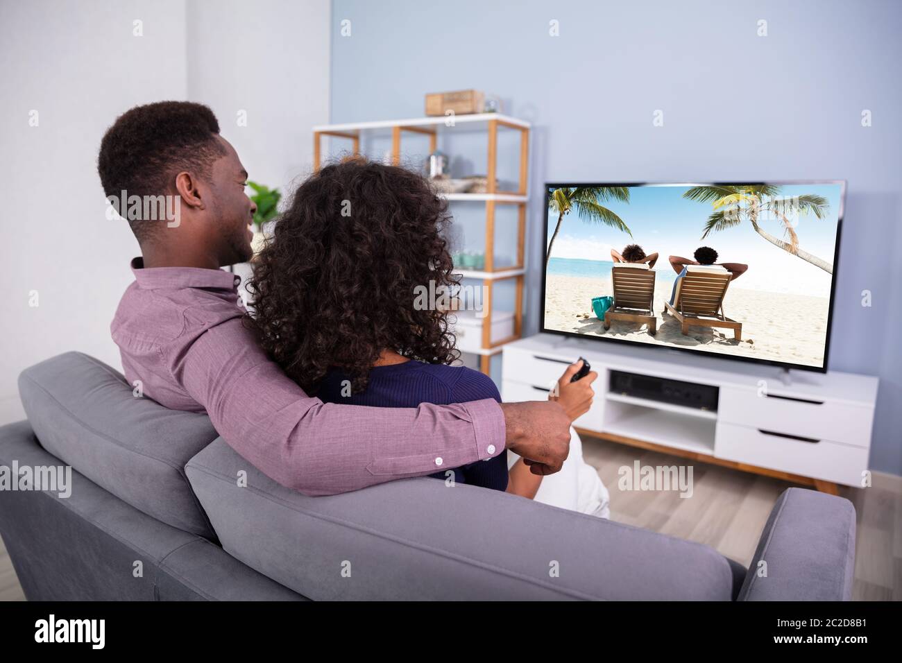 Liebevolle junge Familie Fernsehen zu Hause Stockfoto