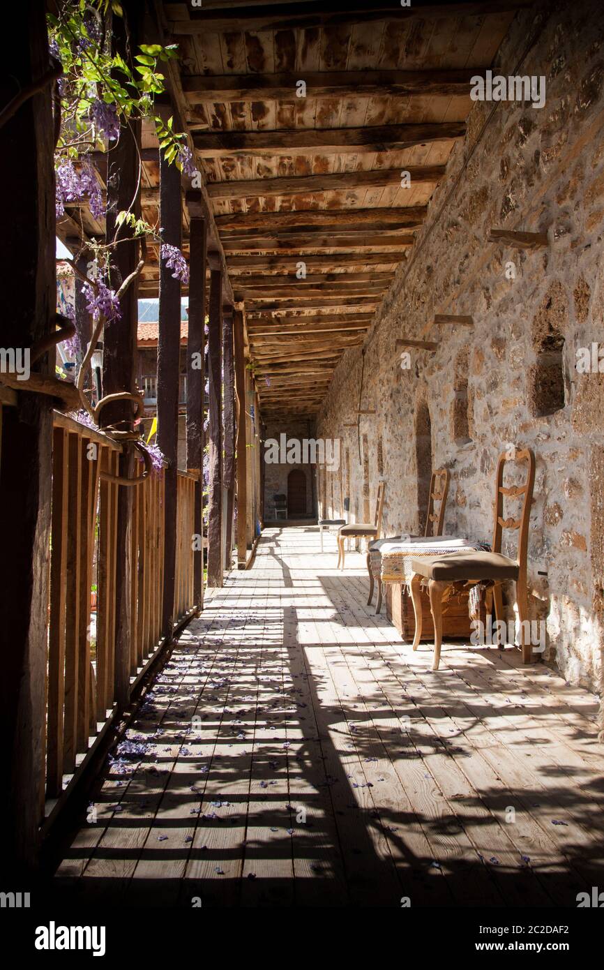 Holzkorridor mit Stühlen im Kloster St. George Feneos, Griechenland. Stockfoto