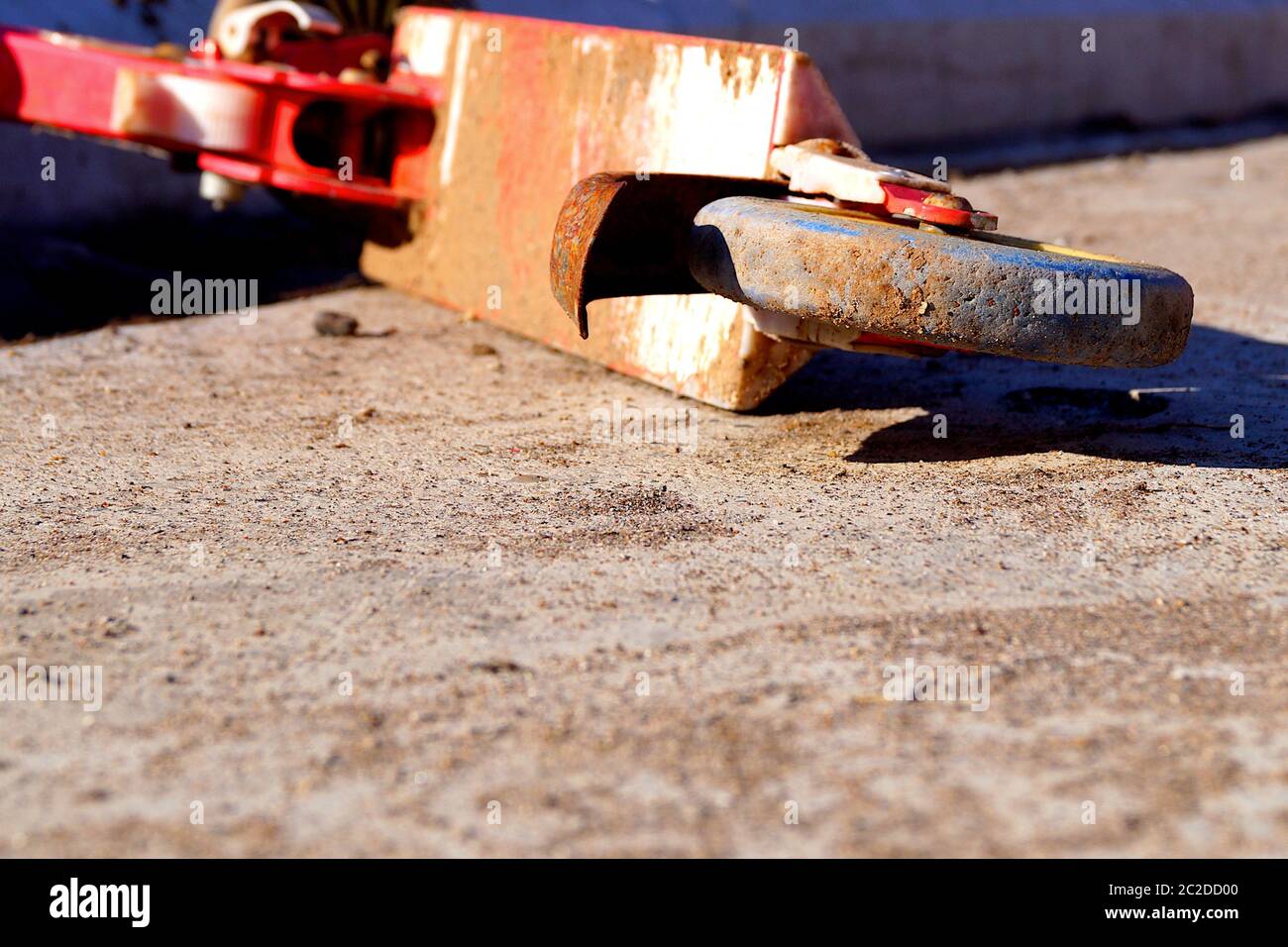 Alte rot rostig verlassene Roller auf dem Betonboden liegen. Stockfoto