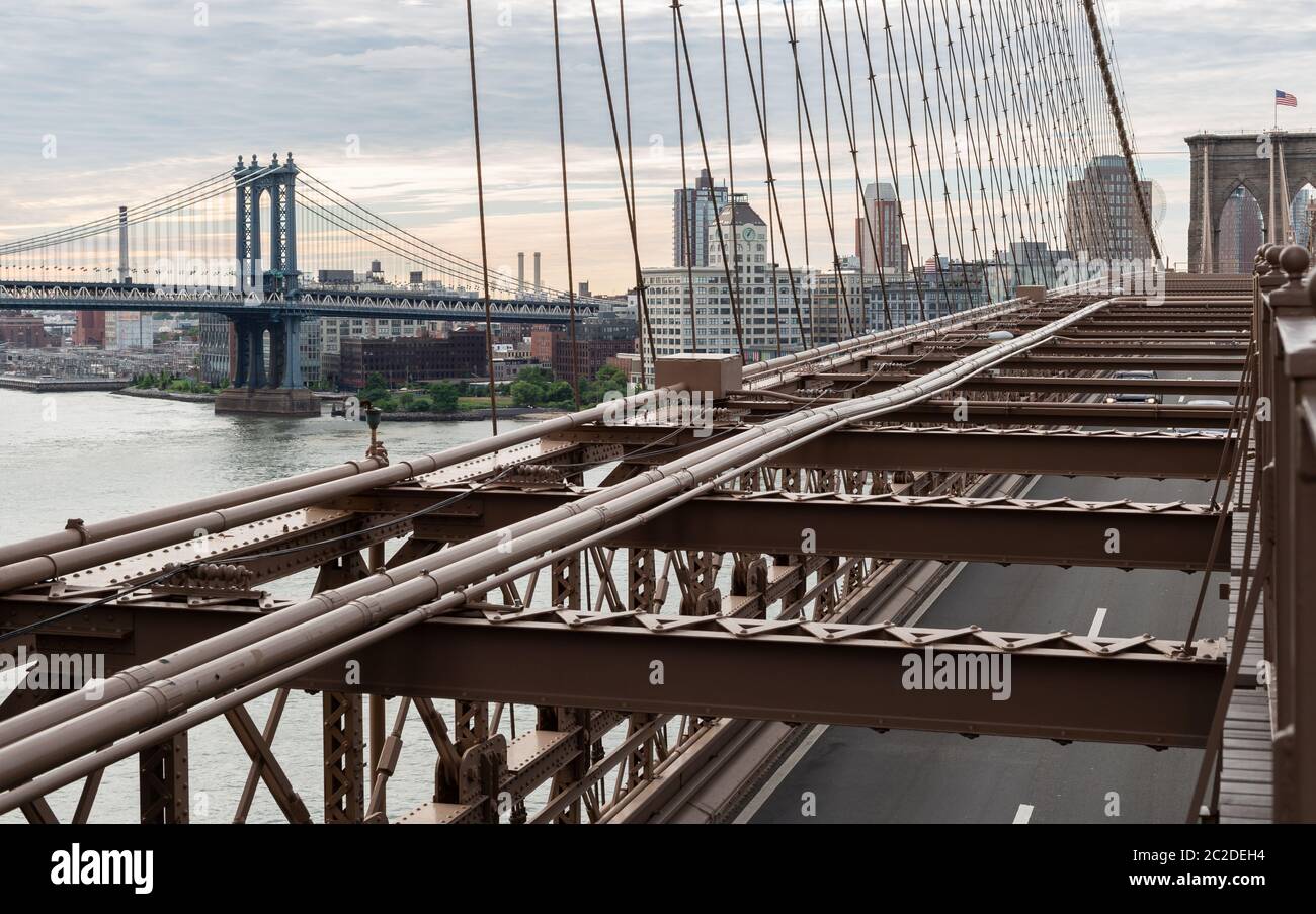 New York City / USA - JUN 20 2018: Brooklyn Bridge mit Manhattan Bridge mit Gebäuden von DUMBO am frühen Morgen in New York Ci Stockfoto