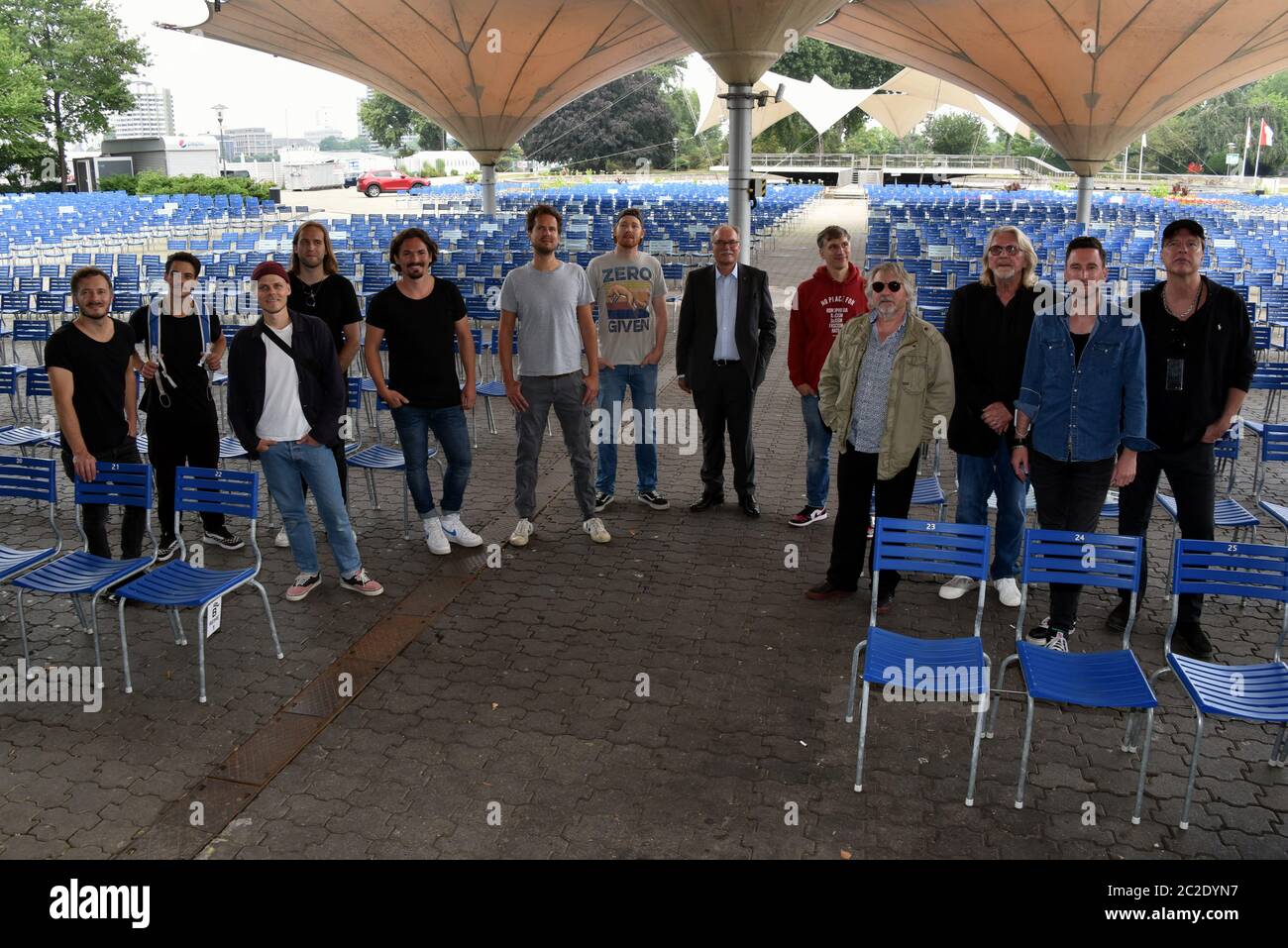 Köln, Deutschland. Juni 2020. Die Kölschrock-Band Cat Ballou (l) und Mitglieder anderer Bands posieren noch immer zwischen den Stühlen des PK für den Neustart der Open Air-Konzertsaison nach den aktuellen Corona-Vorgaben im Kölner Tanzbrunnen. Quelle: Horst Galuschka/dpa/Alamy Live News Stockfoto