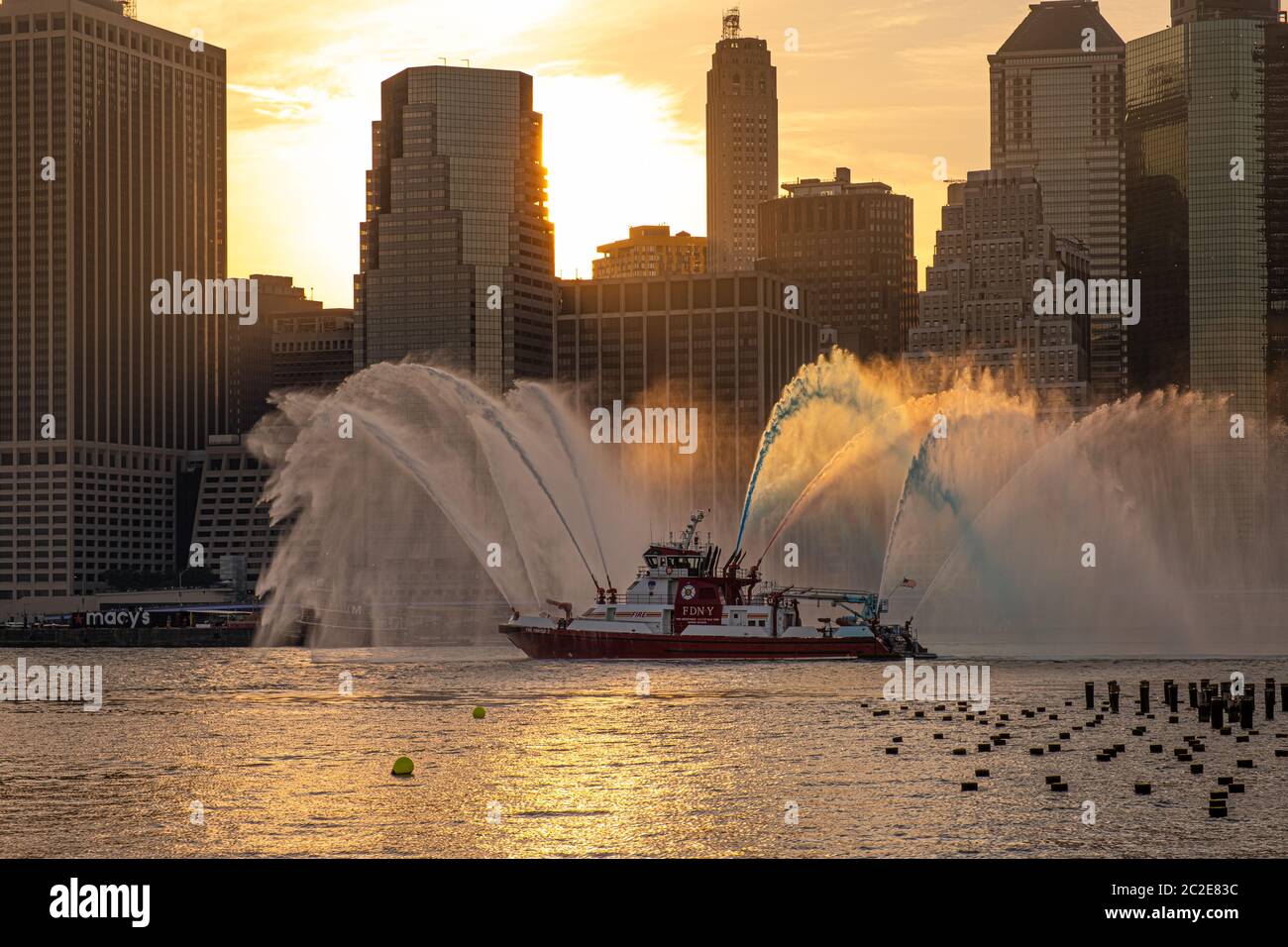 Das FDNY-Boot spritzt vor Macy's Feuerwerk am 4. Juli rot, weiß und blaues Wasser Stockfoto