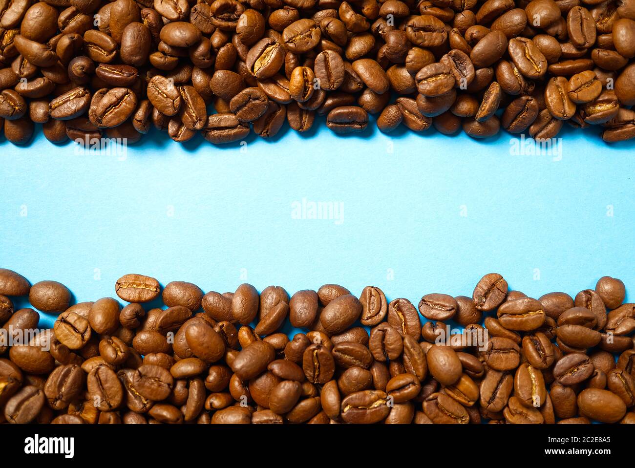 Textur von Kaffeebohnen. Geröstete Kaffeebohnen Hintergrund. Nahaufnahme Kaffeebohnen mit Kopierplatz auf blauem Hintergrund Stockfoto
