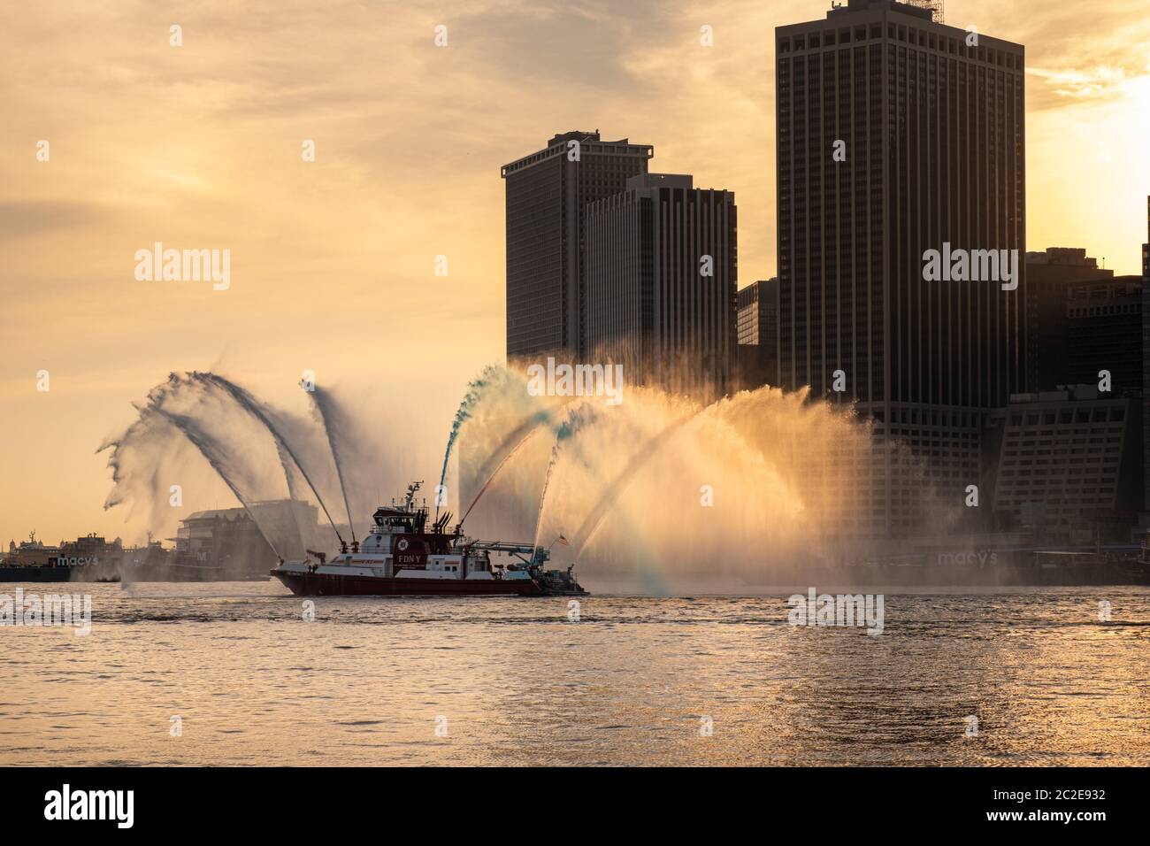 Das FDNY-Boot spritzt vor Macy's Feuerwerk am 4. Juli rot, weiß und blaues Wasser Stockfoto