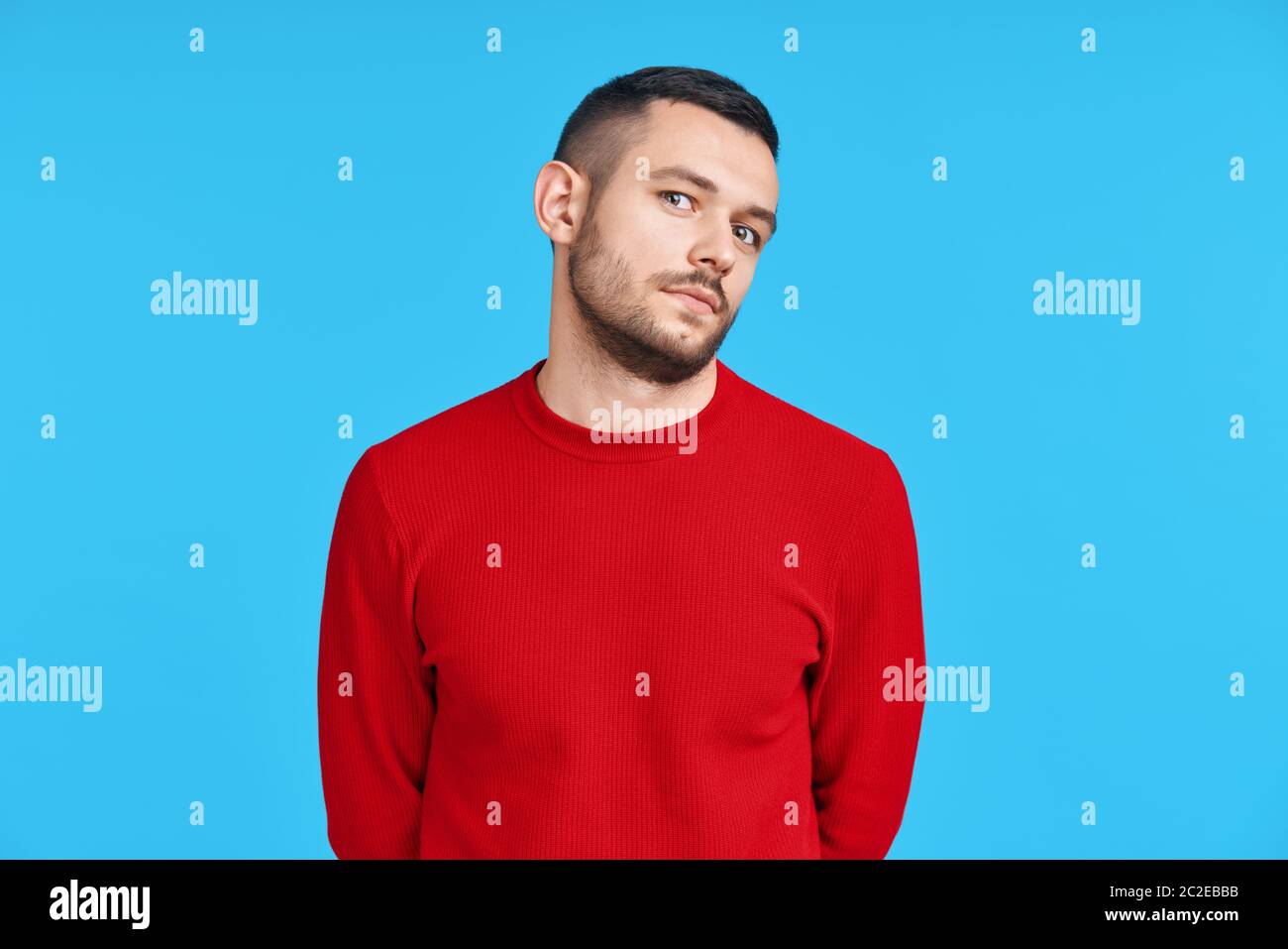 Shy verwirrt Mann Porträt auf blauem Hintergrund Stockfoto