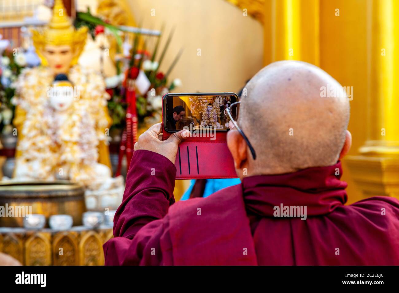 Ein buddhistischer Mönch, der ein Foto in der Shwedagon Pagode, Yangon, Myanmar macht. Stockfoto