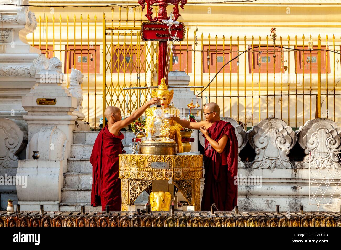 Buddhistische Mönche gießen Wasser über EINE Buddha Statue in der Shwedagon Pagode, Yangon, Myanmar. Stockfoto